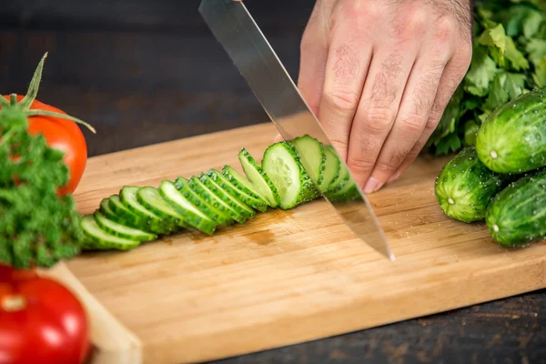 Male hands cutting vegetables for salad