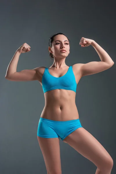 Young athletic girl shows muscles