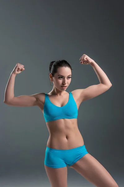 Young athletic girl shows muscles