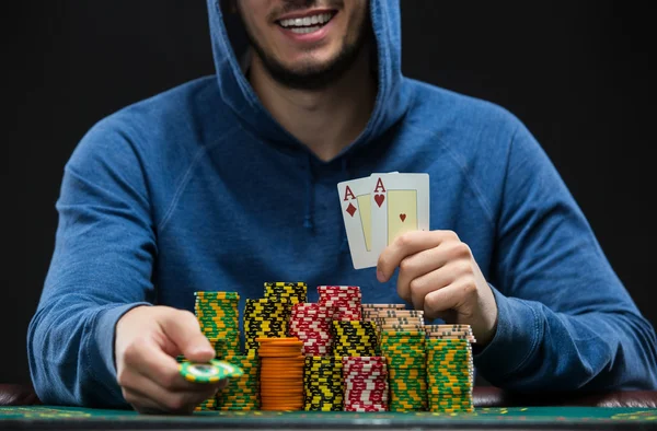 Poker player showing a pair of aces. Closeup