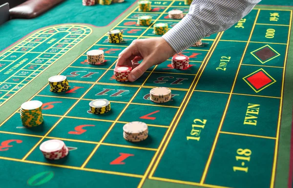 Picture of a green table and betting with chips.