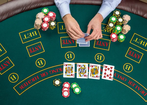 Closeup of poker player with playing cards and chips