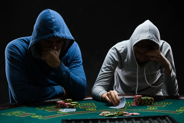Two professional poker players sitting at a poker table