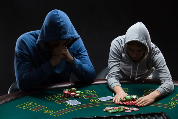 Poker players sitting at poker table and going all-in