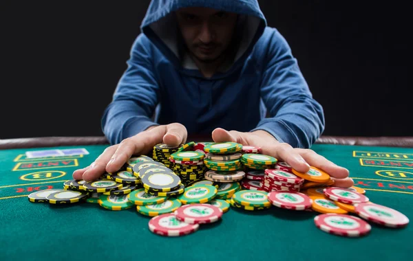 Poker player going all-in  pushing his chips forward