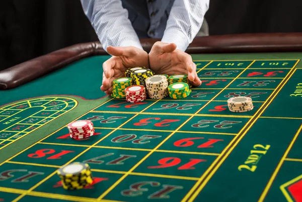 Picture of a green table and betting with chips.