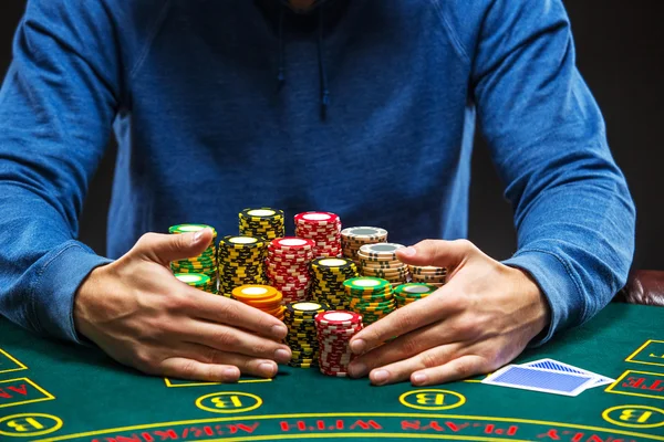 Poker player taking poker chips after winning