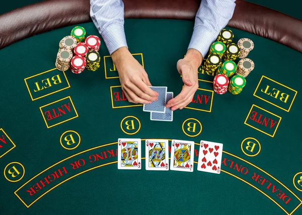 Closeup of poker player with playing cards and chips