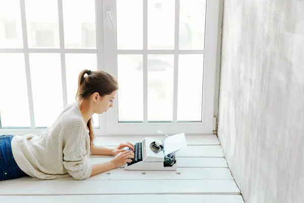 Womans hand typing on retro machine