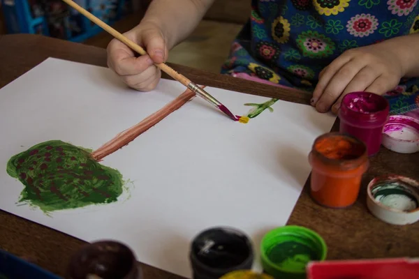 Child drawing with paints