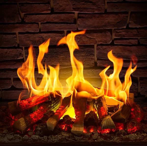 Flames in the fireplace on a background of a stone wall
