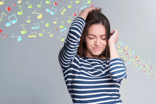 Young beautiful woman listen the music and dance with colorful musical notes on background