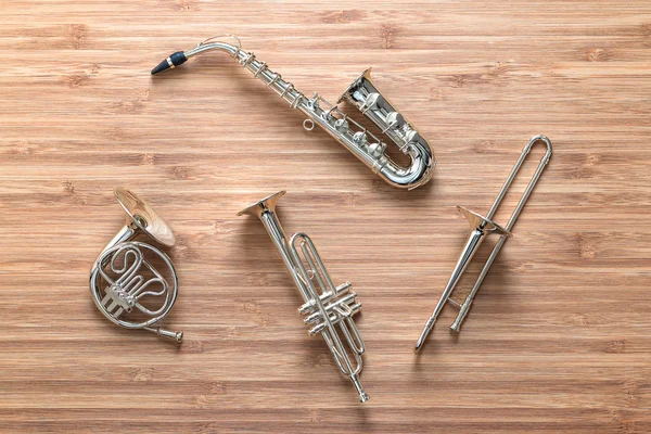 Set of golden toy brass wind orchestra instruments: saxophone, trumpet, french horn and trombone. Music concept.