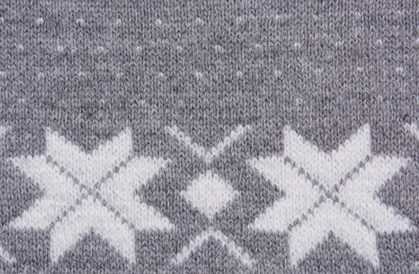 Knitted pattern with white snowflakes. Top view