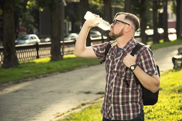 Stylish man drinks water.