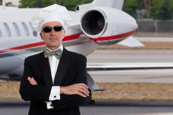 Elegant chef posing in front of a private jet