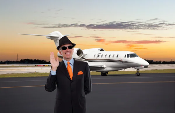Business man waving near a private jet