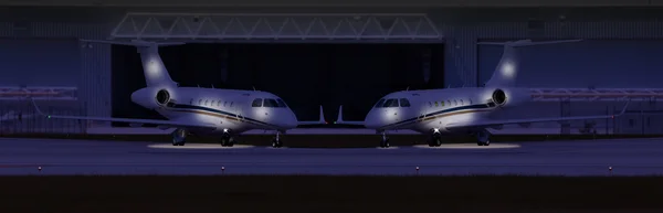 Two private planes in front of a hangar at night