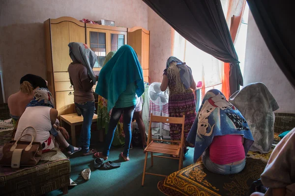 The women hide their faces with towels draped over his head during a police raid on brothels of the city to identify those involved in prostitution.