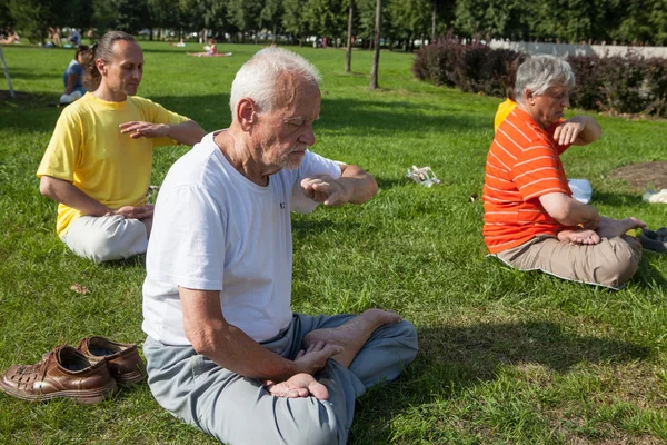 People meditating in a city park