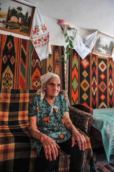 Elderly woman in a hut in the Ukrainian national style