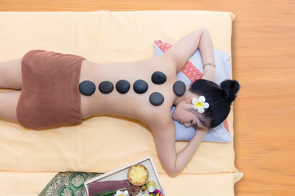 Hot stone therapy lying on back of woman