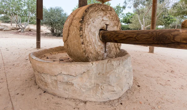 With wooden poles, used for grinding in ancient times