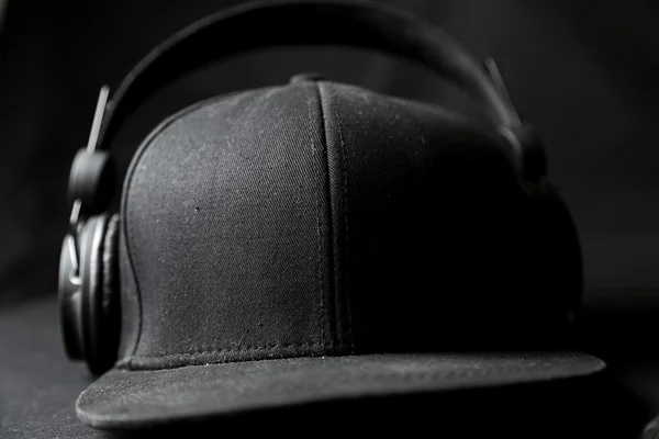 Black headphone with hat on black background