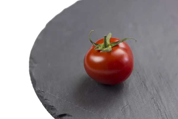 Tomato on black service stone
