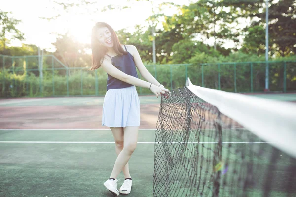 Beautiful asian girl on tennis court after playing tennis