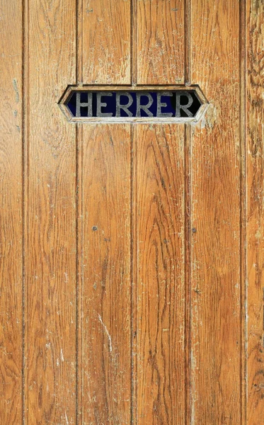 Texture of old wooden door. A men's toilet with the word 