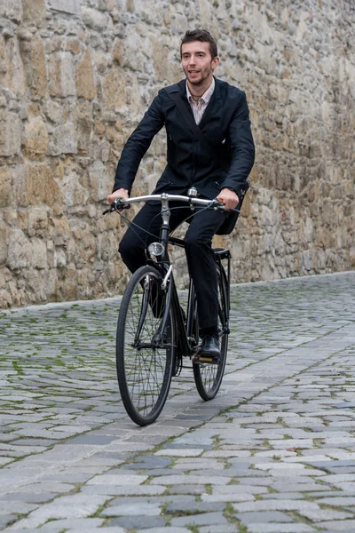 Young casual business man riding his bike