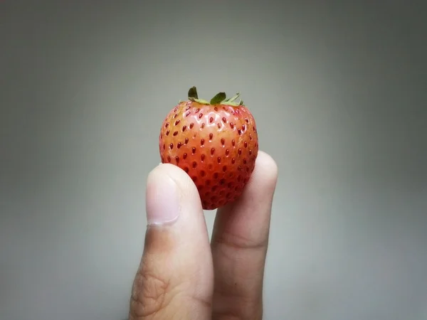 Ripe strawberry in hand