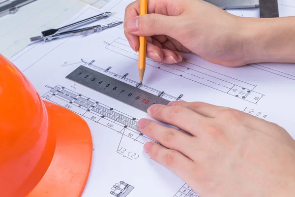 Man\'s hand with a compass. Mechanical engineer at work. Technical drawings. Pencil, compass, calculator and hand man. Paper with technical drawings and diagrams.