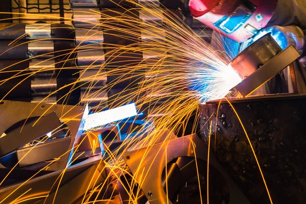 Sparks while welder uses torch to welding