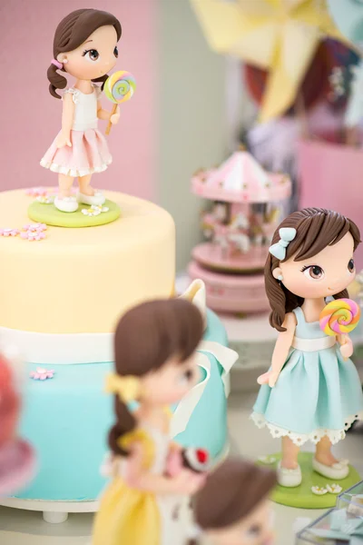 Marzipan dolls next to a girl birthday cake