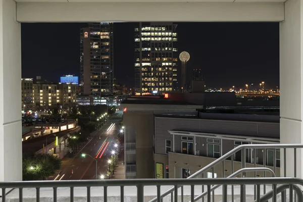 Part of the Dallas Skyline at night framed in a parking garage s