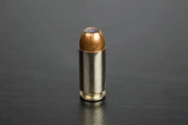 Single bullet for a gun on a black table