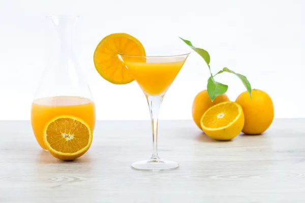 Oranges and glass of juice on a wooden table