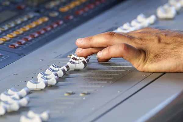 Audio mixer in perspective with hand makes adjustments