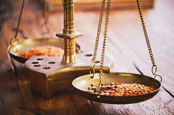 Vintage balance scales with masses weighing red lentil