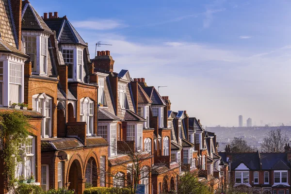 Traditional British brick houses on a cloudy morning with east London at background. Panoramic shot from Muswell Hill, London, UK