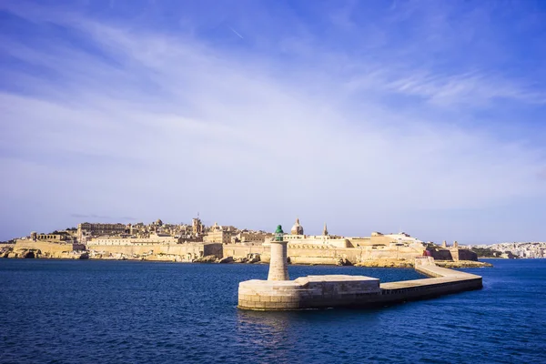 Valletta, Malta - old Lighthouse and Breakwater bridge in the morning with blue sky