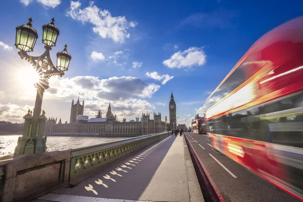 London, England - Iconic Double Decker bus on the move on Westminster Bridge with Big Ben and Houses of Parliament at the background - United Kingdom