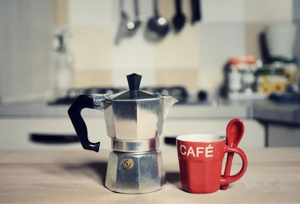 Red coffee cup and  vintage coffeepot on kitchen stove