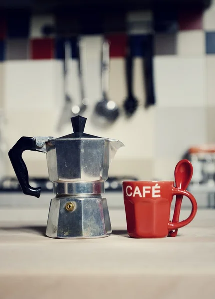Red coffee cup and  vintage coffeepot on kitchen stove