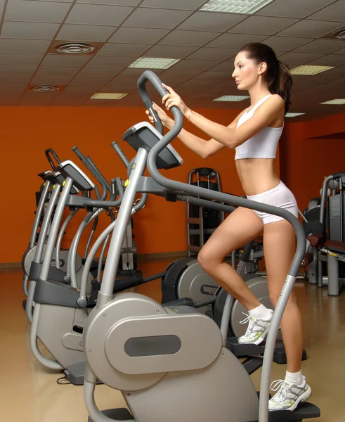 Woman training in gym on stepper machine