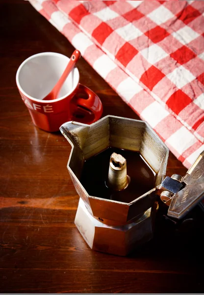 Top view of checkered napkin on wooden table with red coffee cup