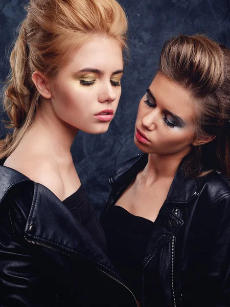 Two young girls posing together with make-up and hairstyles