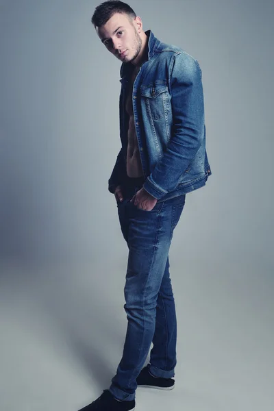 Handsome guy posing in stylish jeans clothes